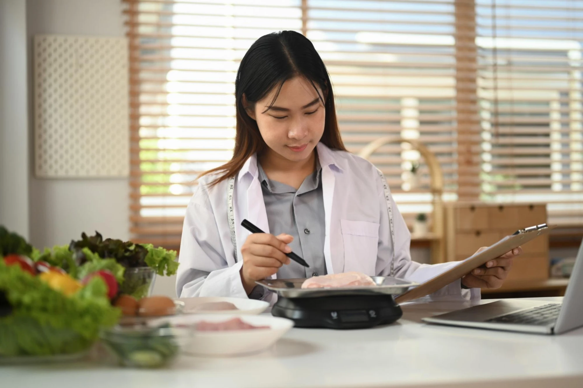 Dietitian weighing food portions and recording client notes